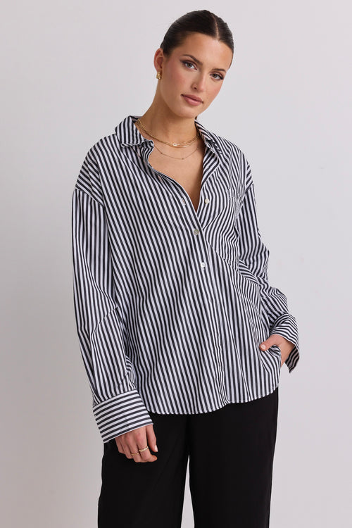 model wears a black and white stripe shirt 