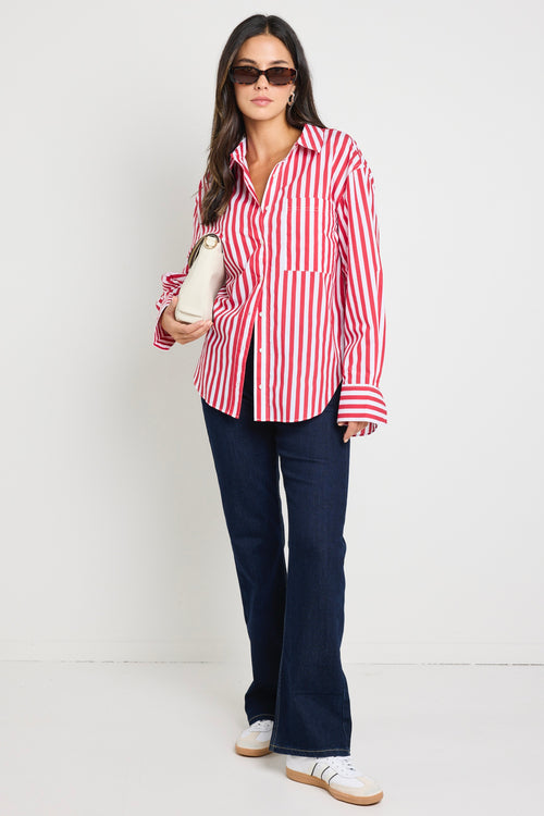 Woman wearing a red and white stripe oversized shirt 
