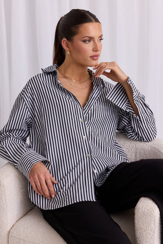 model wears a black and white stripe shirt 