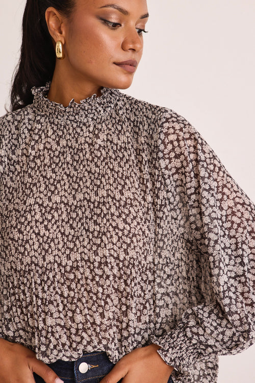 model wears a black print blouse