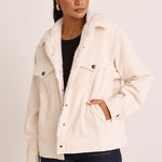 model wears a white cord jacket