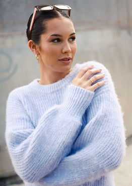 model wears a purple knit jumper