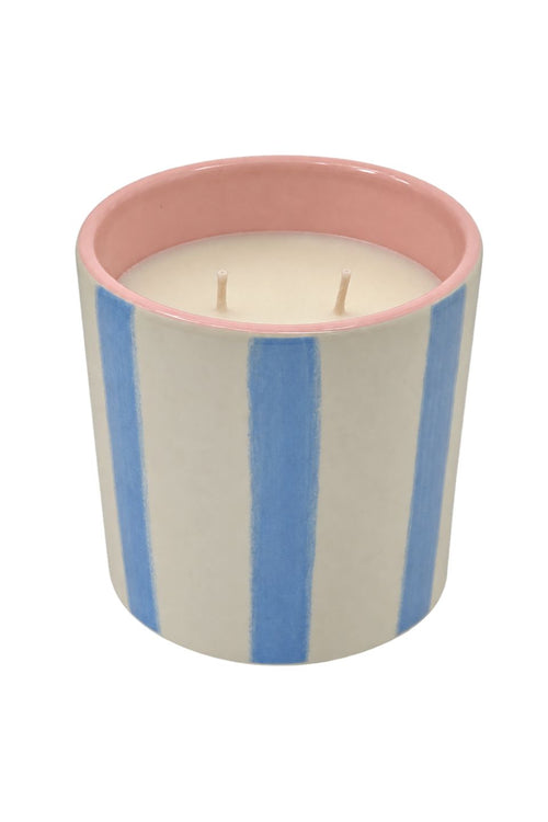 A two-wick scented candle in a cylindrical ceramic pot with vertical blue and cream stripes, featuring a pink interior rim, shown on a plain white background.
