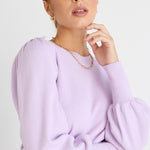 model wears a purple knit