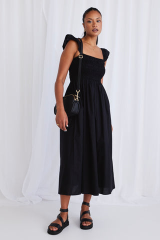 model wears a black dress with black sandals