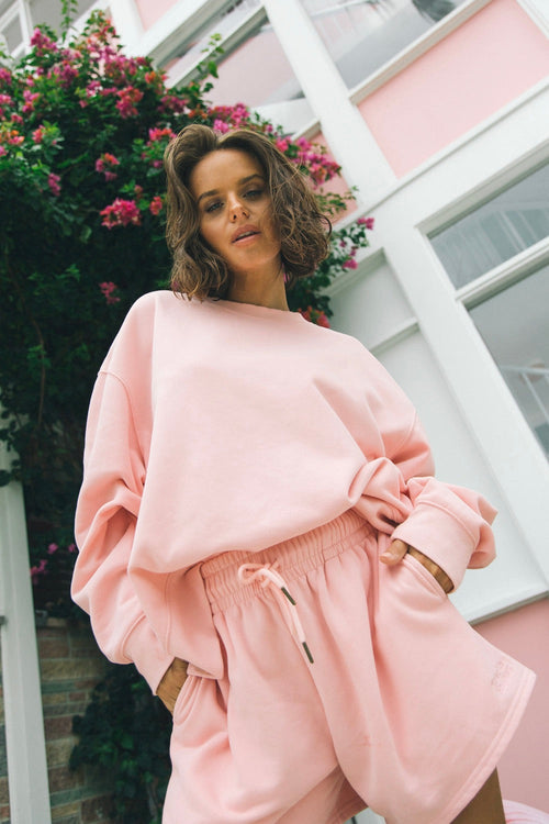 model wears a pink jumper