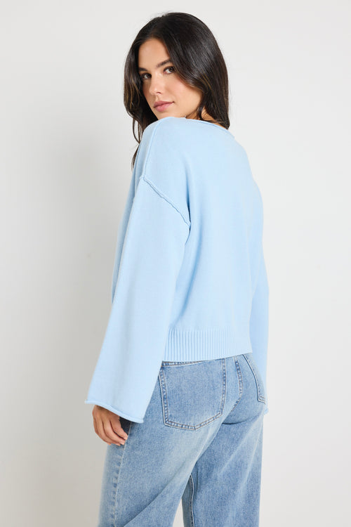 Model wears ice blue knit top