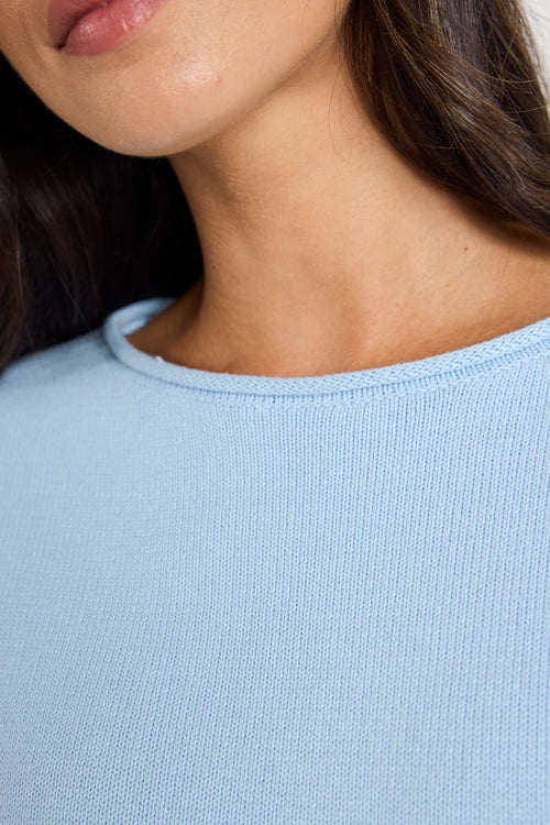 Model wears ice blue knit top