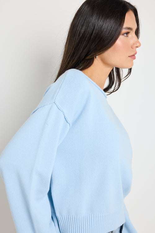 Model wears ice blue knit top