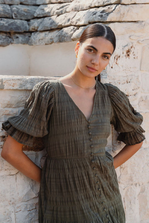 model wears a green midi dress