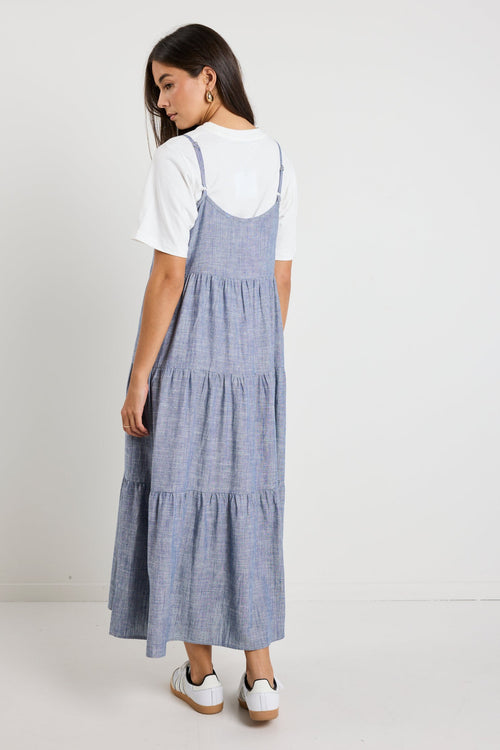 Tiered midi dress features delicate spaghetti straps, a relaxed fit, and functional side pockets for a casual yet chic look.