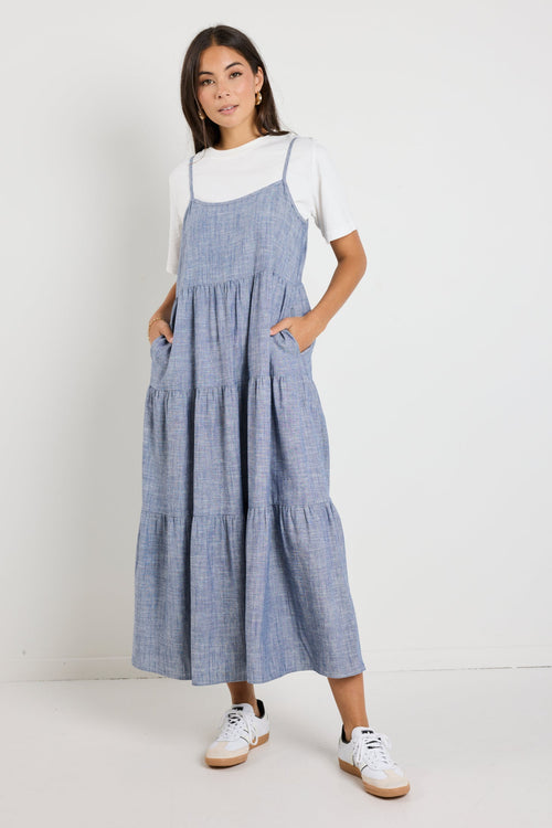 Tiered midi dress features delicate spaghetti straps, a relaxed fit, and functional side pockets for a casual yet chic look.