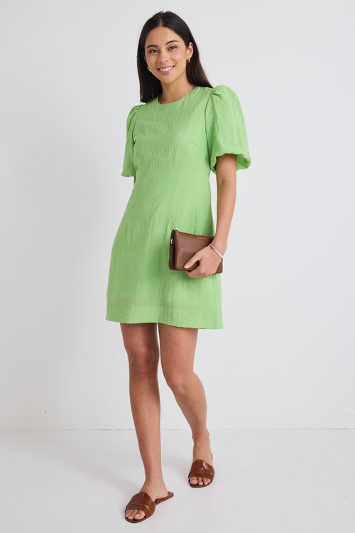 model wears a green mini dress