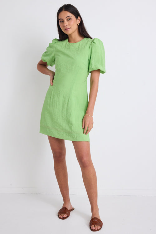 model wears a green mini dress