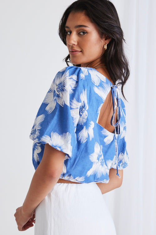 model in blue floral crop top and white skirt