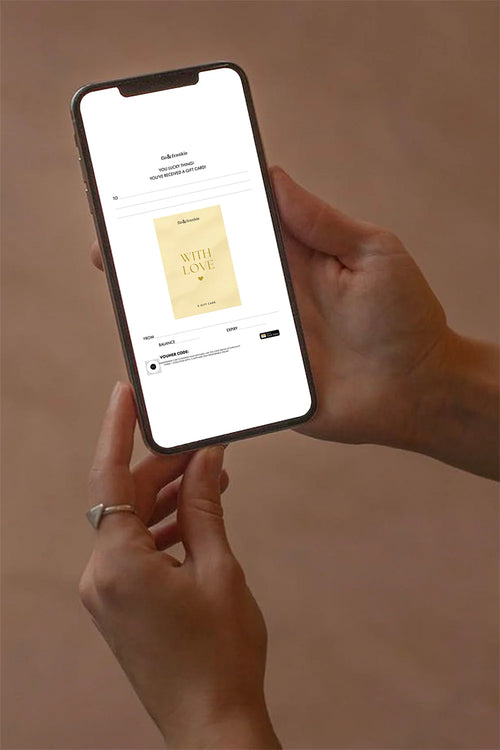 Person holding a smartphone with an app displaying a product on a beige background
