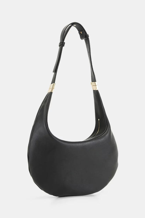 A black leather crescent-shaped shoulder bag with a single shoulder strap and gold-tone hardware, shown against a light gray background.