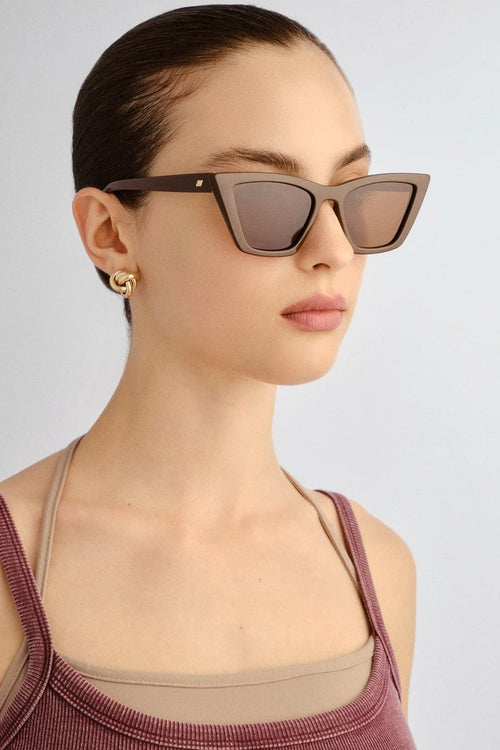 Woman wearing sunglasses with a plain background