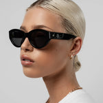 Woman wearing black sunglasses with a plain background