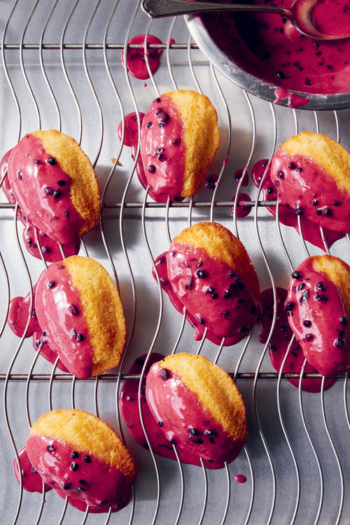 Baked goods with blackberries on a cooling rack next to a recipe text.