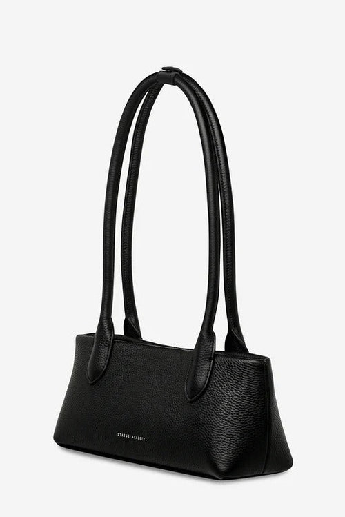 Black handbag with a visible brand name on a light gray background