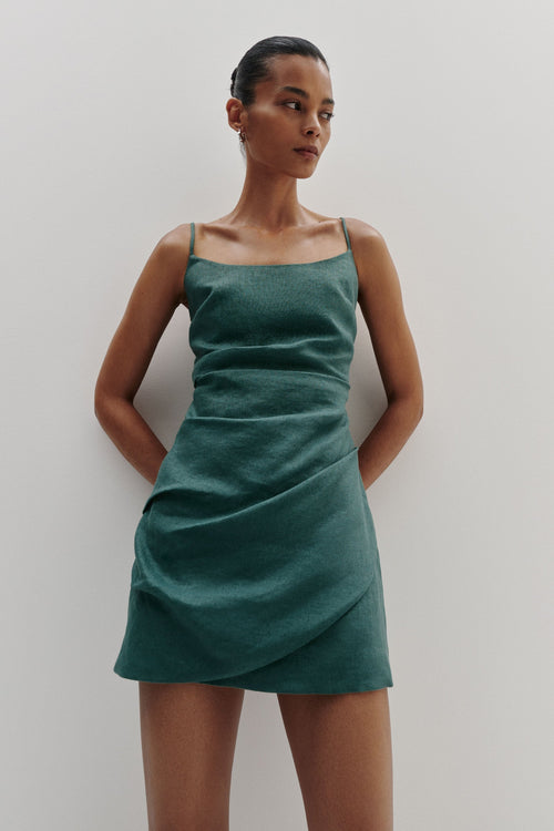 Woman wearing a green dress against a plain background