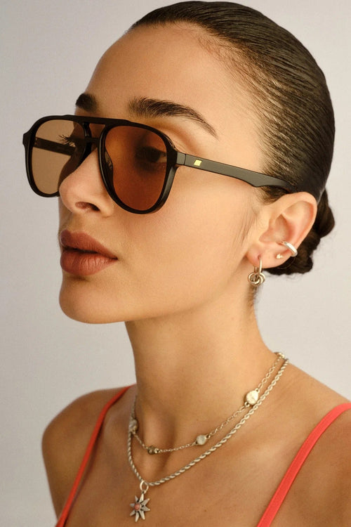 Woman wearing sunglasses with a neutral background