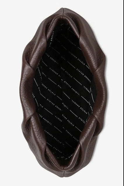 A dark brown leather clutch bag with a gathered, scalloped edge and a black quilted interior, shown from a top-down view on a light gray background.