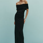 Woman wearing a black off-shoulder gown against a light blue background