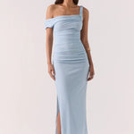 Woman wearing a light blue off-shoulder dress with a slit on a white background