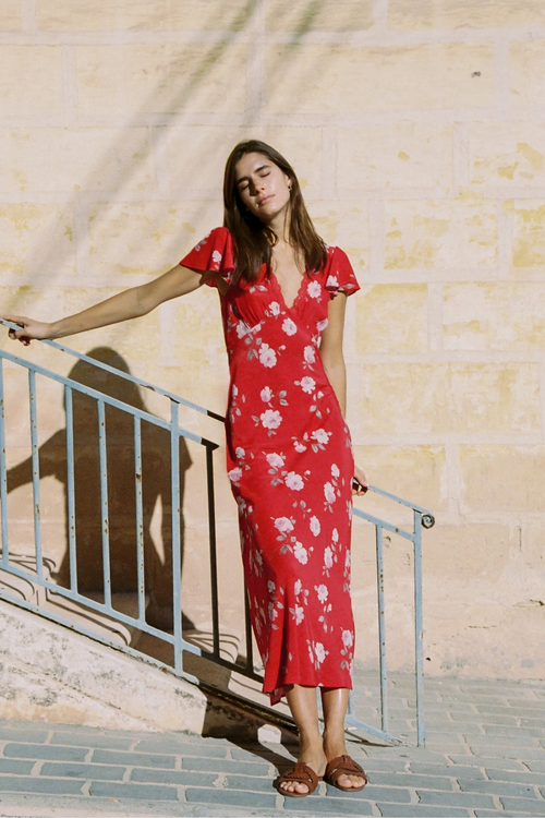 Woman wears a red floral maxi dress
