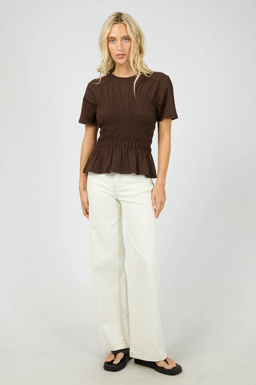 Woman wears a brown ruched top