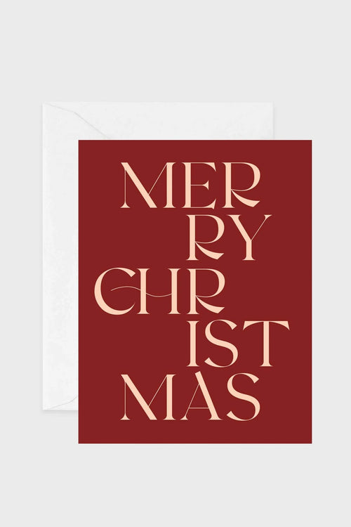 A square Christmas greeting card with a deep red background and elegant cream-colored text reading 'MERRY CHRISTMAS', shown with a white envelope behind it on a light gray background.