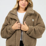 Woman wearing a brown fleece jacket on a white background