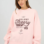 Person wearing a pink sweatshirt with 'Silent Theory' print on a gray background