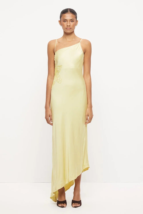 Pale yellow asymmetrical maxi dress with thin straps, scalloped neckline and tonal beaded floral detail at the waist.