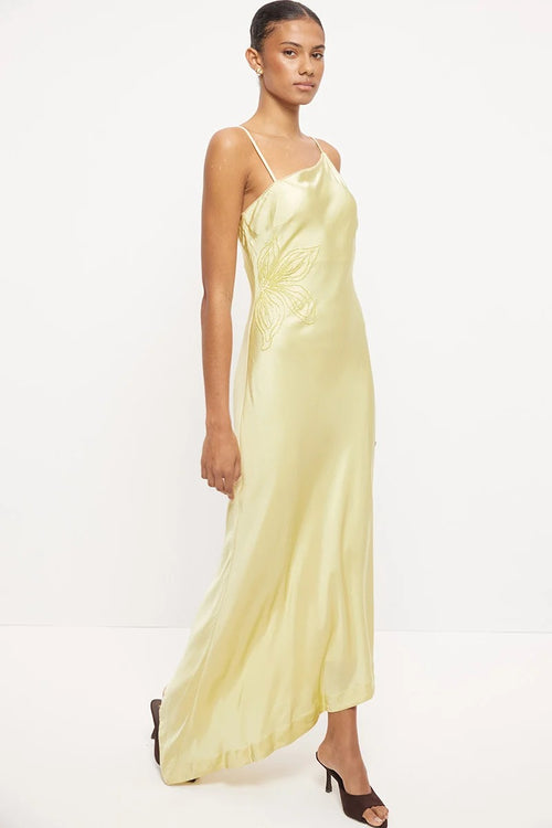 Pale yellow asymmetrical maxi dress with thin straps, scalloped neckline and tonal beaded floral detail at the waist.