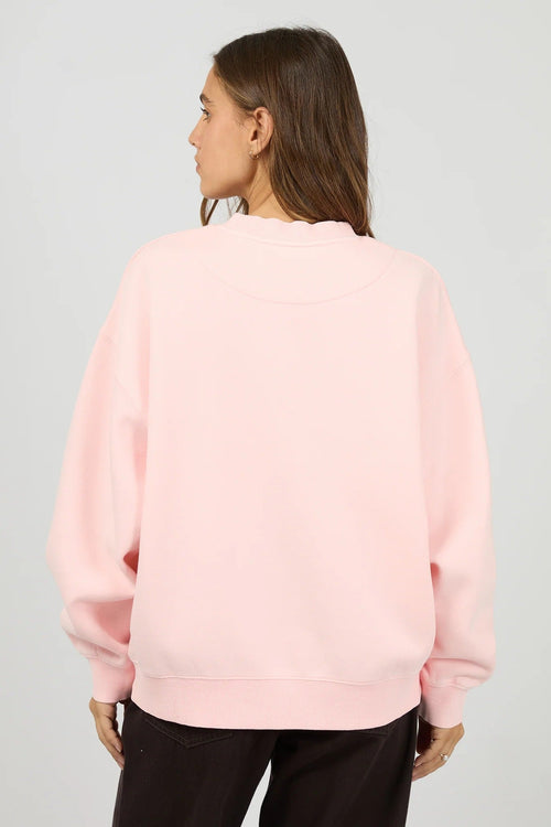 Person wearing a light pink sweatshirt on a plain background