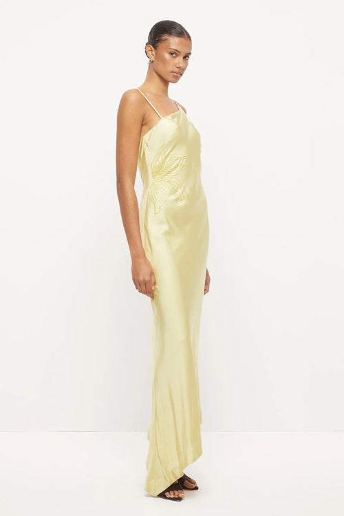 Pale yellow asymmetrical maxi dress with thin straps, scalloped neckline and tonal beaded floral detail at the waist.