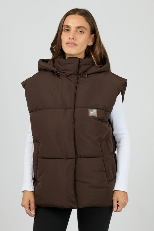 Woman wearing a brown puffer vest on a white background