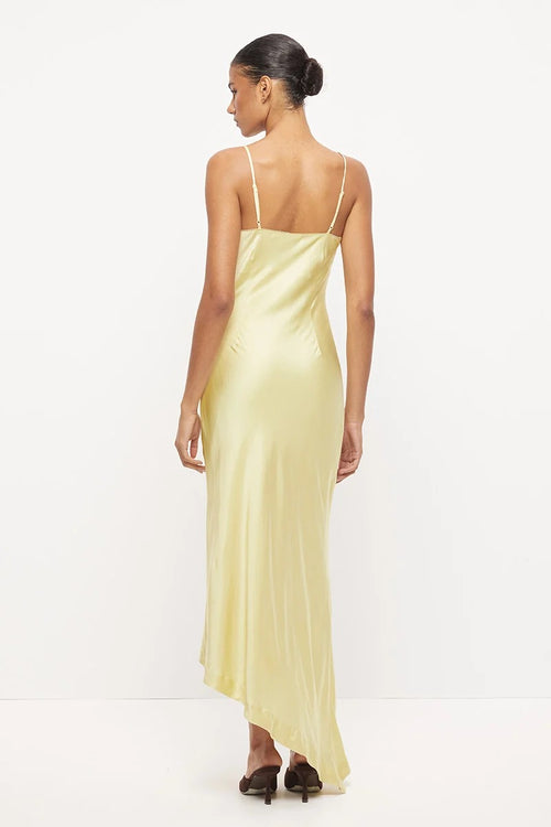 Pale yellow asymmetrical maxi dress with thin straps, scalloped neckline and tonal beaded floral detail at the waist.