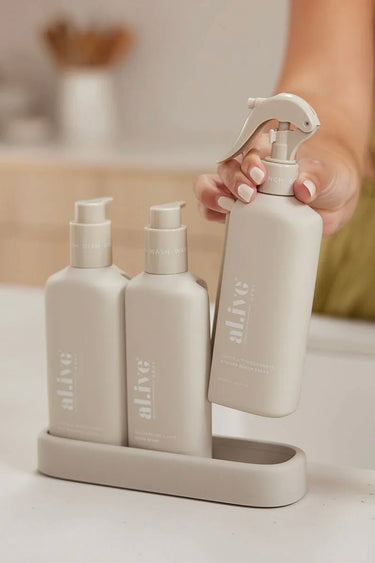 Set of skincare products including bottles and a spray bottle on a stand with a blurred background.