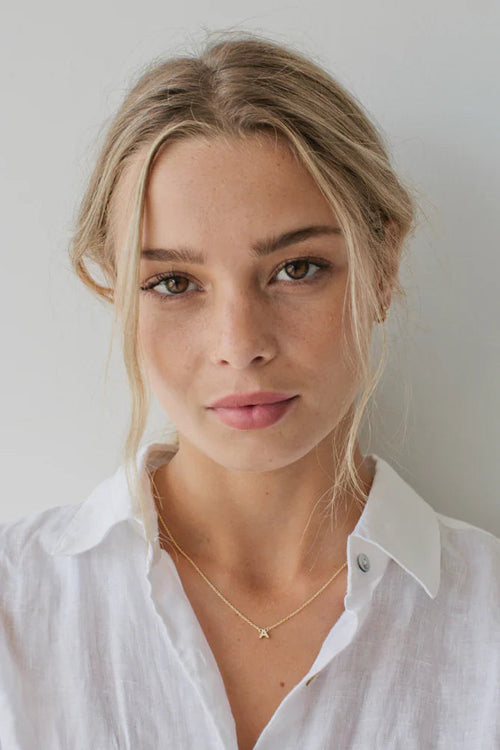 Woman wearing gold letter chain necklace