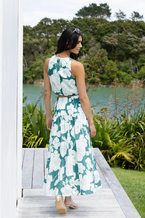 Model wears a green floral skirt and green floral top