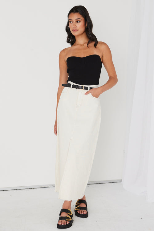 model wearing black bandeau top and white maxi skirt with black belt