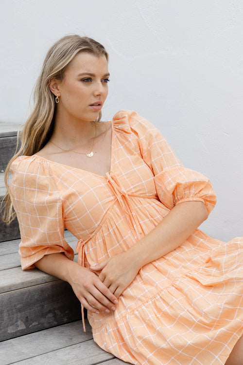 model wears a orange mini dress