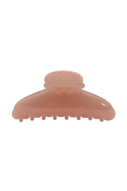 A translucent peach-colored hair claw clip on a solid white background.