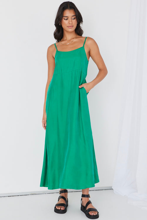 model wears long green cupro maxi dress and black sandals