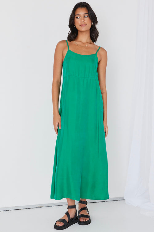 model wears long green cupro maxi dress and black sandals