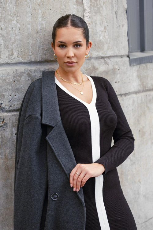model wears a black knit maxi dress